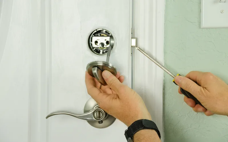 Locksmith installing a new lever lock on a residential door